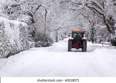 A Red Tractor Driving Down A Snow Covered UK Road During The Winter Snowfall Winter In January 2010