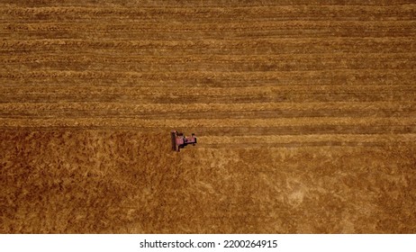 Red Tractor Mowing Cutting Grass On Field. Aerial Top-down Sideways