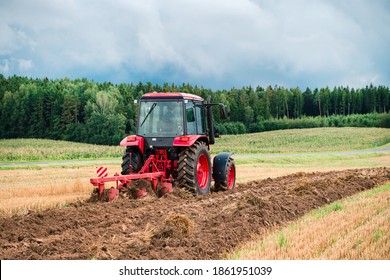 Red Tractor Plowing in Autumn, Farmer plowing stubble field in tractor preparing plows the land, agricultural works at farmlands, agriculture tractor-landscape