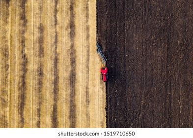 Red Tractor Working On Earth From Aerial Perspective Of A Drone