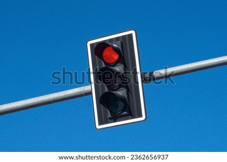 Red traffic light background. Isolated on blue sky. Stop light. Long metal pipe. Simple empty copy space background. Road warning. Safety rules. Do not drive. Wait for green.