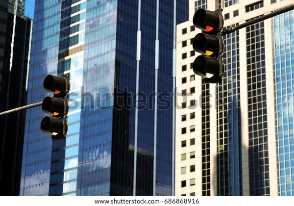 REd\
Traffic Light in the city. high-rise buildings\
behind