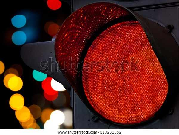 Red traffic light with colorful unfocused\
lights on a background