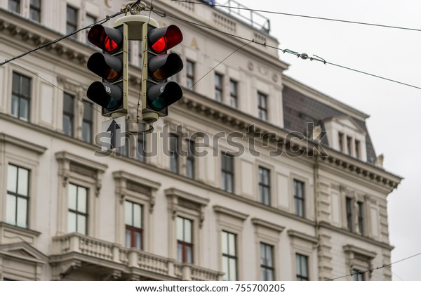 Red traffic\
light in front of an old\
building