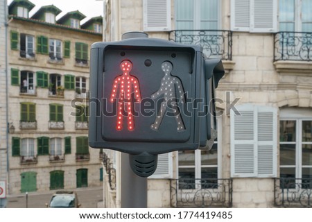 Red traffic light. Image of the red colored figurine of a man. Stop sign for pedestrians. Architecture of ancient city as background.
