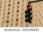 Red traffic light in New York City, USA. Traffic light and in the background the facade with windows of a residential building and the American flag. Traffic light in Foley Square.