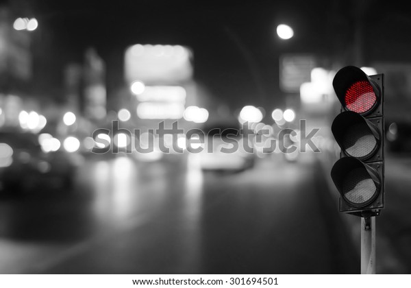 Red traffic light on\
the road in night city. dangerous signal stop crash driving\
highway,expressway. Blurred background of car dark fast truck\
surveillance security.