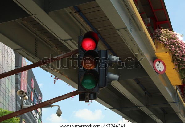 Red Traffic\
light on a street over a\
building