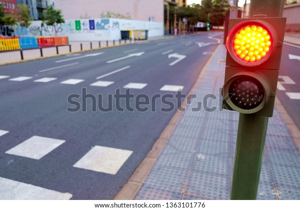 Red traffic light\
at pedestrian crossing.