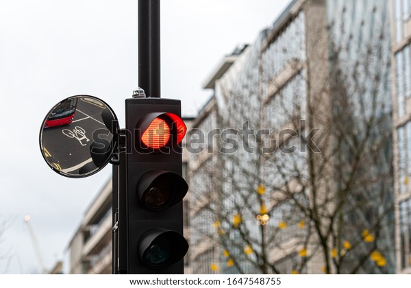 Red Traffic Light Signal and Traffic\
Convex Mirror with the Reflection of the red\
bus