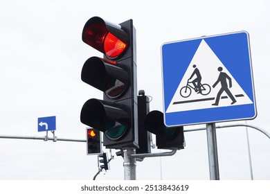 Red traffic light signal. Rainy foggy day intersection. Smart traffic light. City crossing with semaphore. Pedestrian crossing road sign. Bad weatherd road conditions. Gray sky and low visibility.  - Powered by Shutterstock