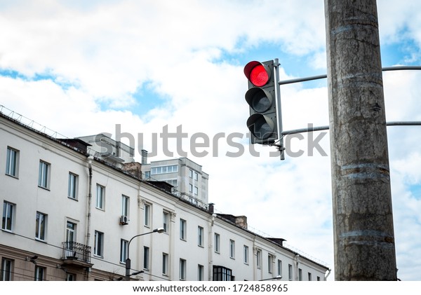 Red traffic light\
suspended from a pole.