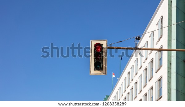Red traffic lights for cars in the city
center, blue sky background