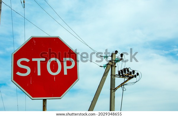 Red traffic stop\
sign on a background of blue sky and power lines. Sign on the\
background of the cloudy\
sky.