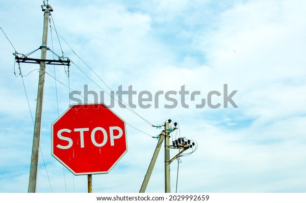 Red traffic stop\
sign on a background of blue sky and power lines. Sign on the\
background of the cloudy\
sky.