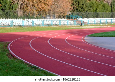 Red Treadmill With White Lines In A Sports Stadium. Red Running Tracks In The Stadium. Empty Sport Stadium. Treadmill Is Covered With Red Rubber Coating. 