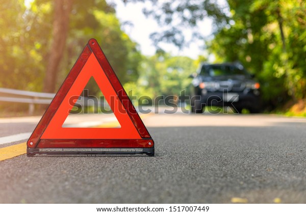 Red triangle, red emergency\
stop sign, red emergency symbol and black car stop and park on\
road.