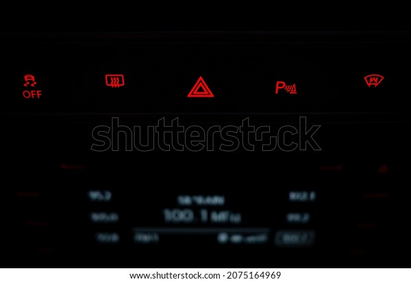 Red triangle emergency stop symbol. Control\
panel with red night illumination in the car. Buttons with red\
symbols in the car\
interior.