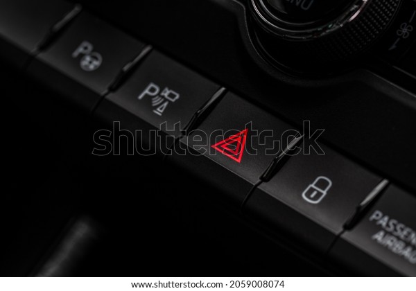 Red\
triangle hazard light button on car dashboard. Car media buttons\
dashboard. Detail of a modern car\
controllers.