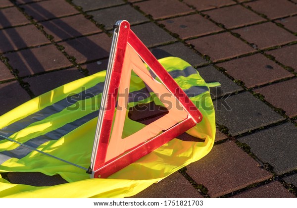 Red triangle\
warning sign and yellow safety\
vest