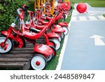 Red tricycles line up beside a track in a children