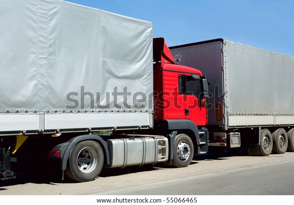 Red truck with cargo\
container in port