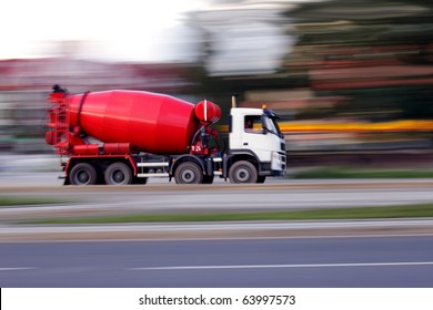 Red truck concrete mixer, panning and blur
