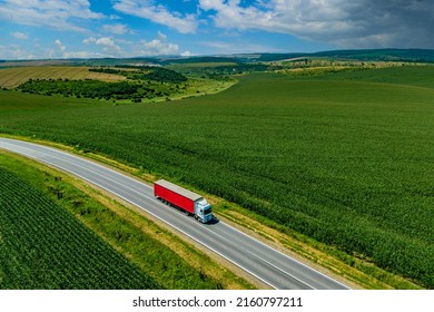 red truck driving on asphalt road along the green fields. seen from the air. Aerial view landscape. drone photography. cargo delivery . cargo delivery and transportation concept  - Shutterstock ID 2160797211