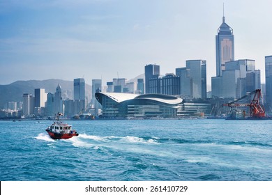 Red Tug Boat In Victoria Bay In Front Of Hong Kong Skyline