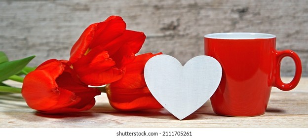 Red Tulips With Coffee Mug And Wooden Heart Shape On Rustic Wooden Table