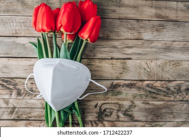 Red Tulips And Mask Kn95 On Rustic Wooden Background. Top View With Copy Space. Happy Nurse Day. Covid-19 Concept.