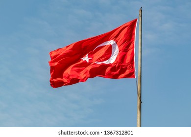red turkish flag with moon and star on flagpole	