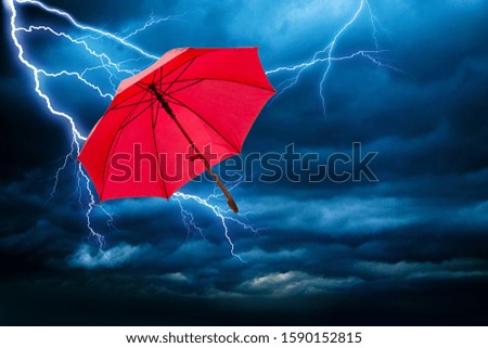 red umbrella and dramatic sky