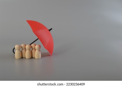 Red umbrella and the group of workers. Medical insurance, labor safety and health protection Insurance coverage concept. - Shutterstock ID 2230236409