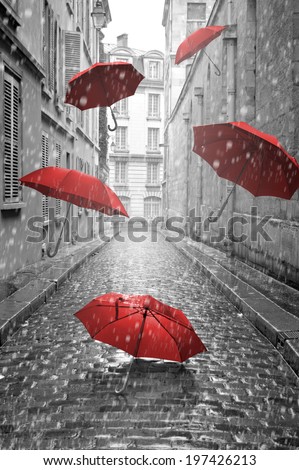 Red umbrellas flying on the street. Conceptual, surreal image.