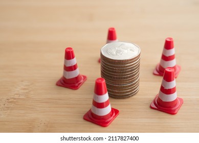 Red Under Construction Cone Around Stacked Coins. Global World Economy Inflation Crisis, Repair, Fix, Revise Or Reset Investment Plan, Money Saving Management. Business, Financial And Economy.