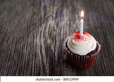 Red Velvet Birthday Cupcake With Candle On Wood Background