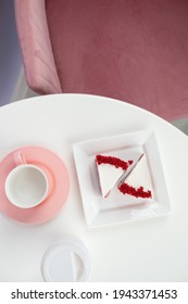 Red Velvet Cake On A White Table With A Pink Tea Mug