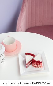 Red Velvet Cake On A White Table With A Pink Tea Mug