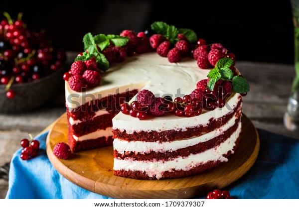 Red velvet cake on wood\
board. Slice of cake. Raspberry cake. Devil\'s cake. Wedding\
dessert. Birthday party. Delicious dessert. Traditional american\
dessert
