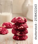 Red velvet cookies with white chocolate chips on white wooden board and white background