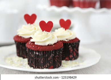 Red velvet cupcakes with cream cheese frosting decorated with chocolate hearts