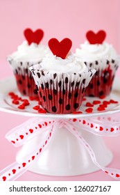 Red velvet cupcakes with cream cheese frosting decorated with red chocolate hearts