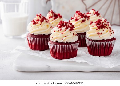 Red velvet cupcakes with cream cheese frosting and red velvet crumbs on a cake stand - Powered by Shutterstock