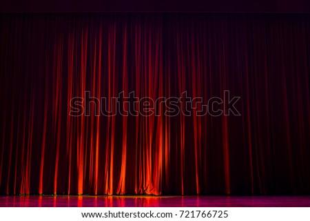 Red velvet curtains with the lights of the show and the wood flooring parquet.
