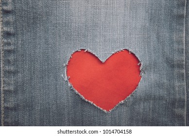 Red velvet in decorative ripped denim heart frame. - Powered by Shutterstock