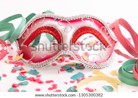 red venetian mask with confetti isolated on a white background.