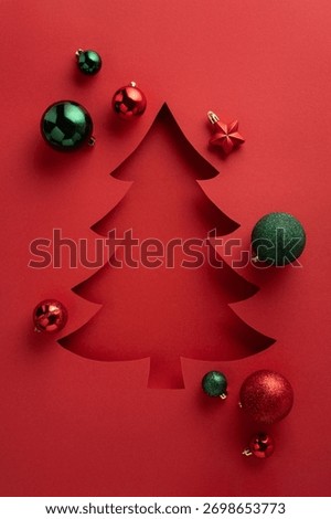A red vertical backdrop features a stylized Christmas tree cutout surrounded by green and red ornaments, creating a festive holiday scene ideal for greeting cards and seasonal projects
