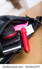 red vibrator in a handbag