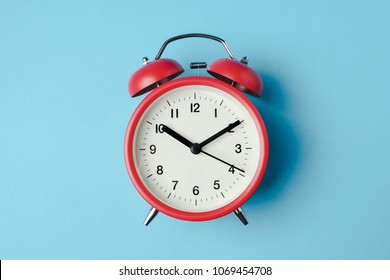 Red Vintage Alarm Clock On Light Blue Color Background